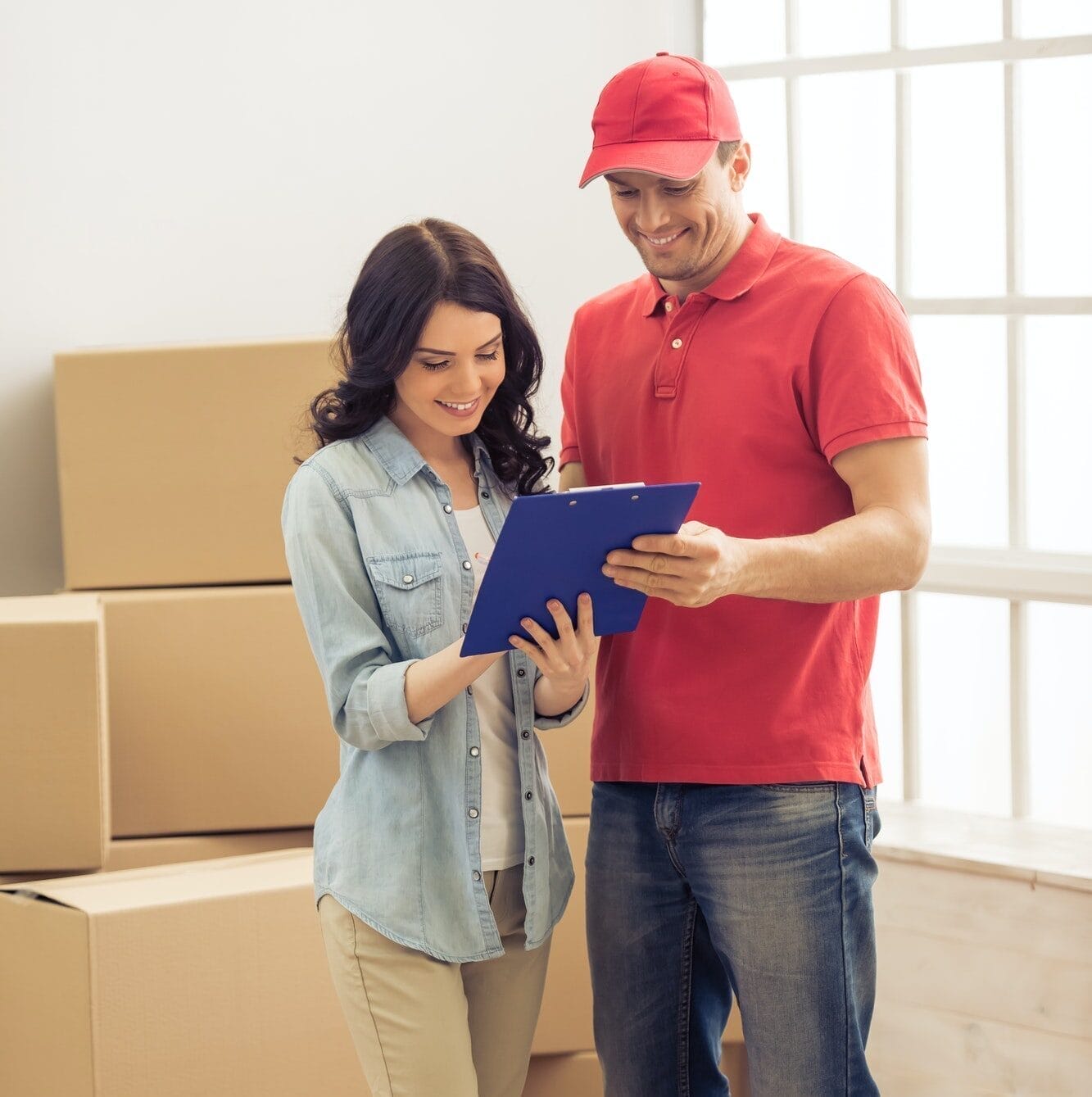 A family carrying boxes into a new apartment, symbolizing the process of moving to a new home.